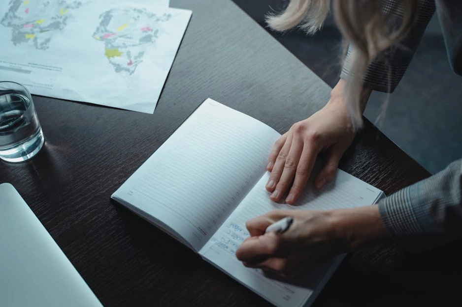 Человек делает записи в блокноте, планируя запуск бизнеса.